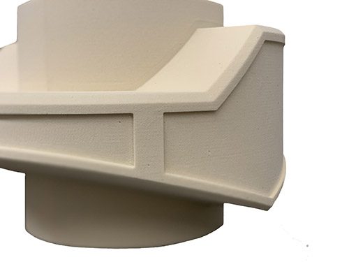 Close view of a cream-colored milled urethane foam part with straight ribbed edges and a fine, even surface texture.