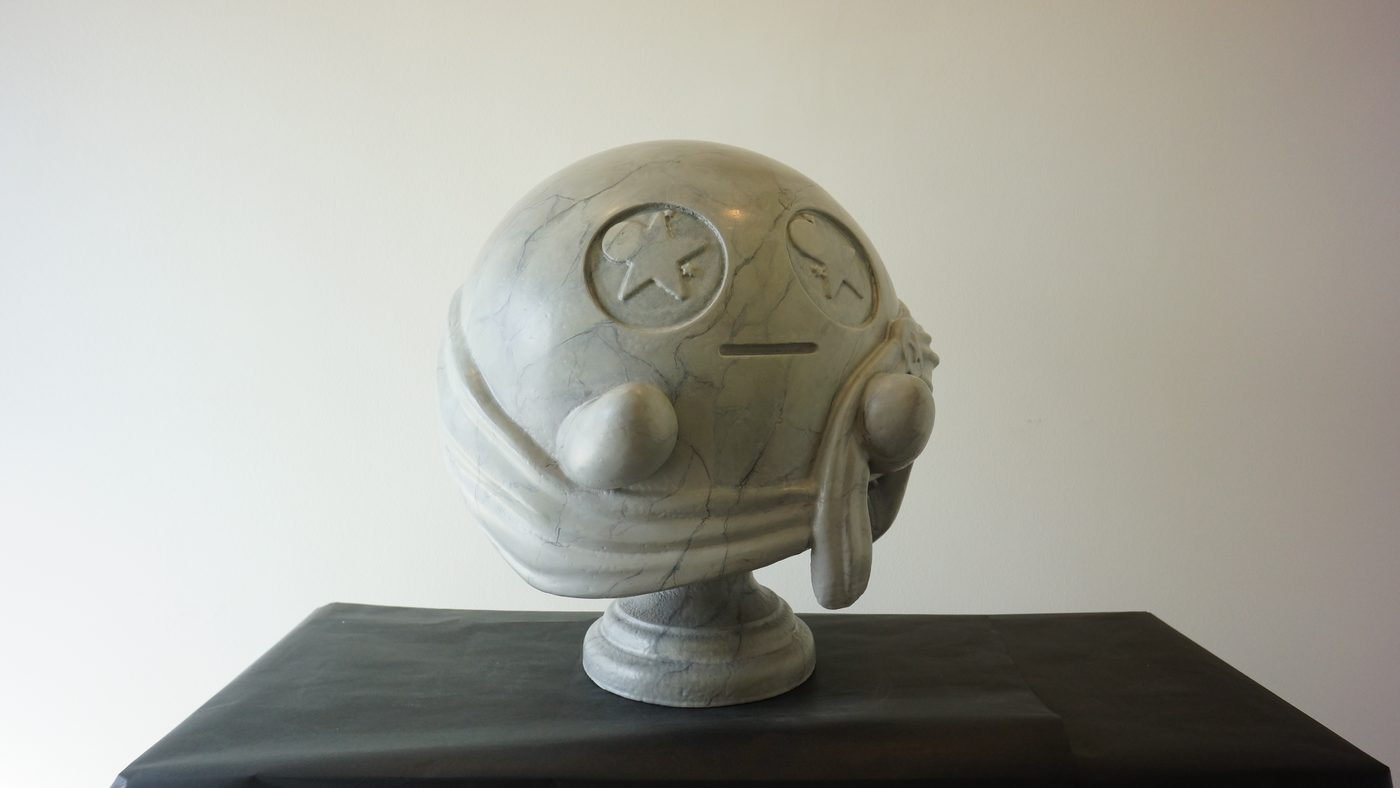 Round sculpted helmet with star-emblem eyes and a scarf, painted in a gray-white marble effect on a matching pedestal